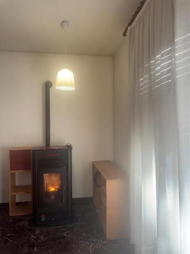 Tamika's House في أوديني: غرفة معيشة مع موقد ونافذة