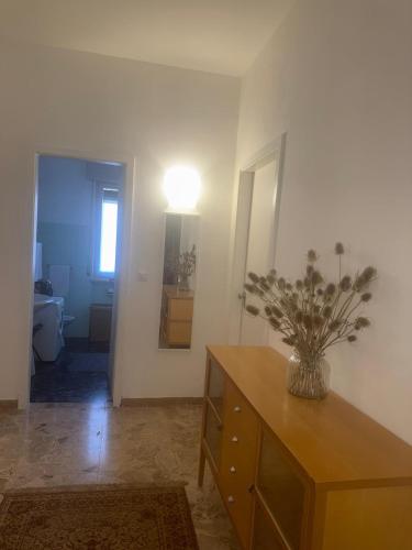 a room with a dresser with a vase on it at Tamika's House in Udine