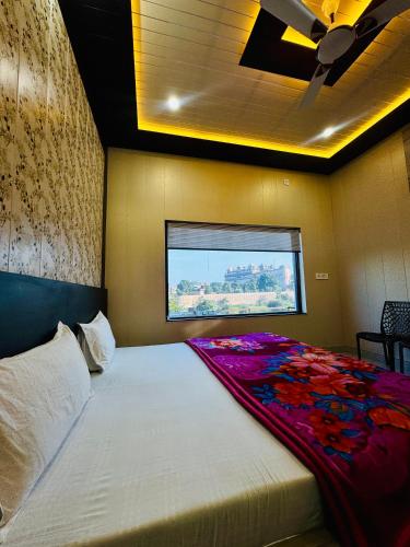 a bedroom with a large white bed with a window at hotelsiyashreeram in Orchha