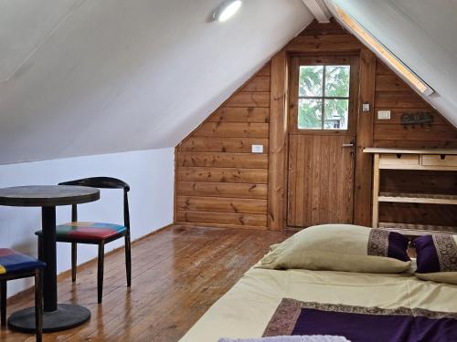a bedroom with a bed and a table in a attic at חאן בשביל היער in Ta‘oz