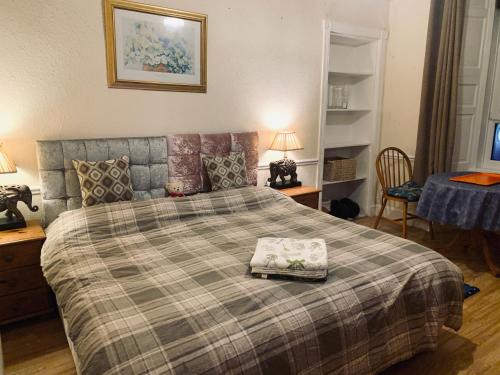 Un dormitorio con una cama con una manta a cuadros. en Twin room close to Royal Troon free parking, en Irvine