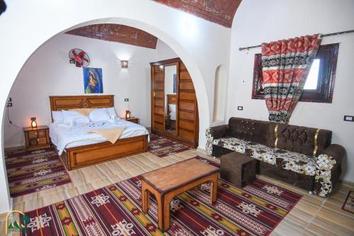a bedroom with a bed and a couch at amzran hotel siwa امزران سيوة in Siwa