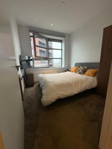 Un dormitorio con una cama grande y una ventana. en Luxurious and Spacious Central London room in Canary Wharf with a City View & a Private Bathroom, en Londres