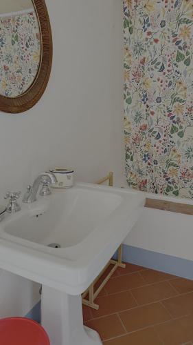 a bathroom with a white sink and a mirror at Poggiarello 10 in Guardistallo