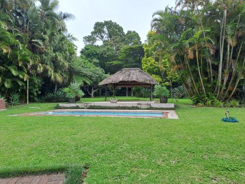 un patio trasero con piscina y cenador en Sabs Place, en Gillitts