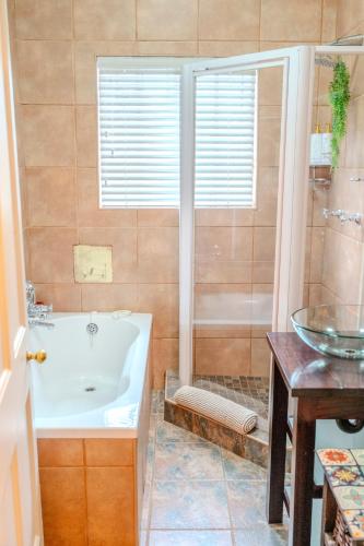 a bathroom with a tub and a sink at SUMMER PLACE in Harrismith