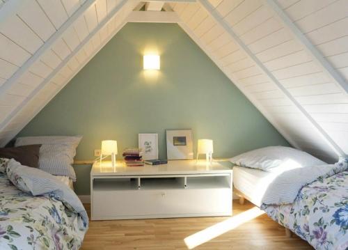 een kamer met 2 bedden en een bureau op zolder bij Ferienhaus Clara in Wardenburg