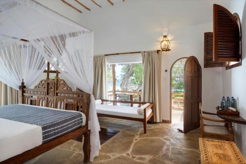 a bedroom with a bed and a window at Waterlovers Beach Resort in Diani Beach