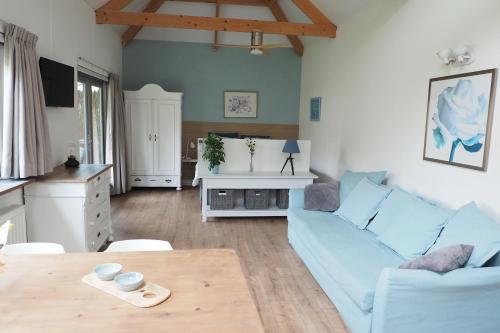 een woonkamer met een blauwe bank en een tafel bij Woubrugge Logies in Woubrugge