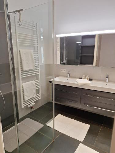 a bathroom with two sinks and a glass shower at Innsbruck Residence in Innsbruck