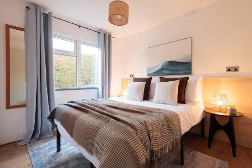 a bedroom with a large bed and a window at Secluded Sanctuary On The River in Christchurch