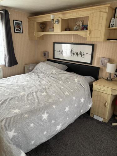 een slaapkamer met een bed met een wit dekbed bij Bobbys Bolthole2 in Heysham