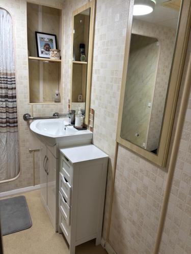 een badkamer met een wastafel en een spiegel bij Bobbys Bolthole2 in Heysham