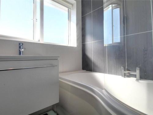 Cozy Guest Room in Family Home, Close to Aldershot Town Centre في ألدرشوت: حمام مع حوض ومغسلة ونافذة