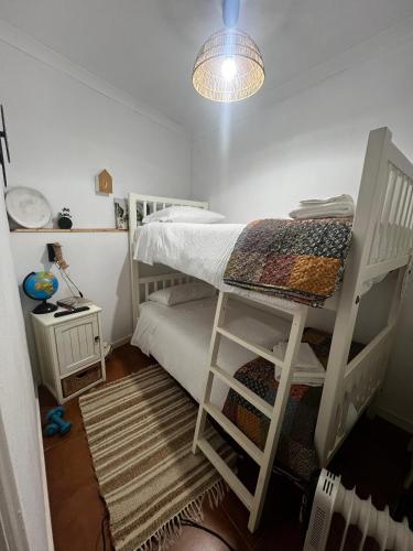 a bedroom with two bunk beds and a lamp at Juniors Country House in Vila Boim