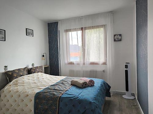 Appartement Le Bargy في Scionzier: غرفة نوم بها سرير عليه منشفتان