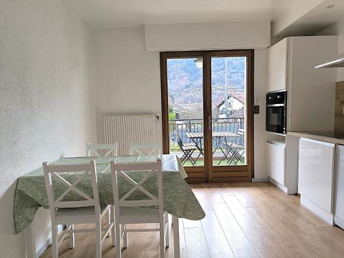 Appartement Le Bargy في Scionzier: مطبخ وغرفة طعام مع طاولة وكراسي