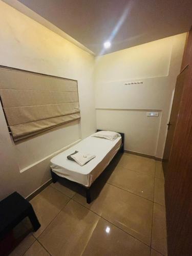 a small room with a small bed in it at Atholi Residency in Mukkam