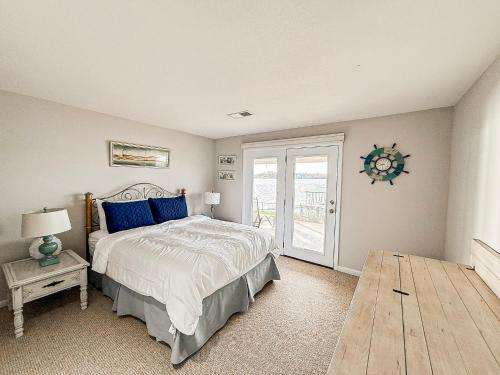 een slaapkamer met een bed met blauwe kussens en een raam bij Edgewater-Lakefront 3 BD25BADeckDockGril-16P in Laguna Beach