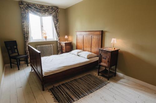 a bedroom with a bed and a table and a window at Pilsbrūzis in Odziena