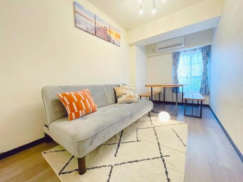 a living room with a couch and a table at 新宿駅まで12分渋谷駅まで22分最大8名様宿泊可能4ベッドルーム in Ogikubo