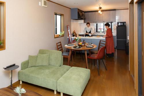 ein Wohnzimmer mit einem Sofa und einem Tisch in der Küche in der Unterkunft 一棟貸 風kaze in Ōgaki