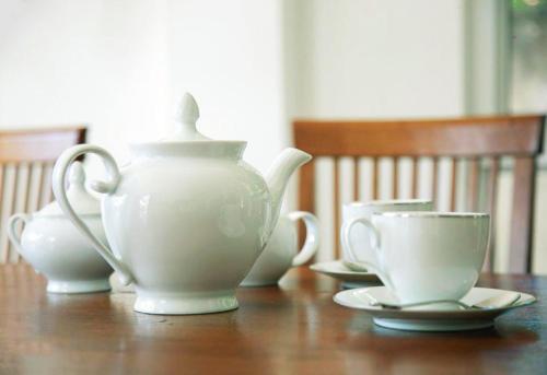 una tetera y dos tazas en una mesa de madera en Heavens Talpe, en Talpe