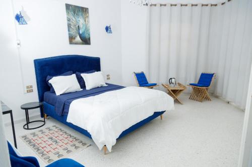 Dar Ali - Comfort stay في توزر: غرفة نوم بسرير ازرق وكرسيين ازرق