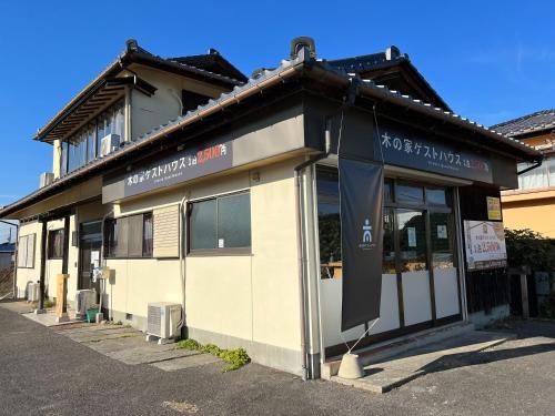 a building with a sign on the front of it at 木の家ゲストハウス郡山本館 in Koriyama