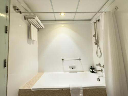een witte badkamer met douche en toilet bij Town in Town Hotel Bangkok in Bangkok