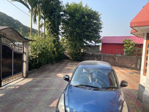 a small blue car parked in a driveway at Rigerous Valley in Khairāni