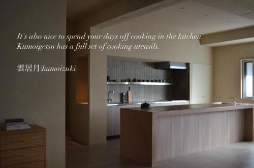 a kitchen with a counter with a sign on the wall at 雲居月-kumoizuki- in Ginowan