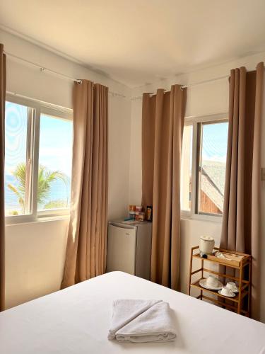 a bedroom with a bed and two windows at Salamya Guesthouse in San Juan