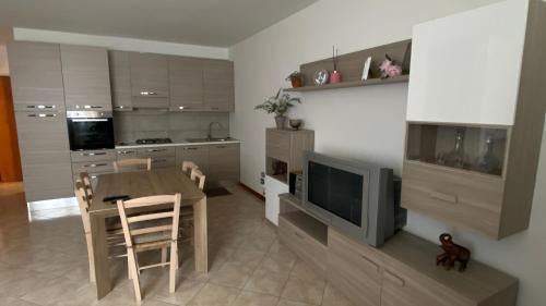 a kitchen with a wooden table and a television at Casa Hellen in Lonedo