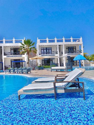 a resort with two beds and a swimming pool at Protels La Plage Resort in Bwejuu