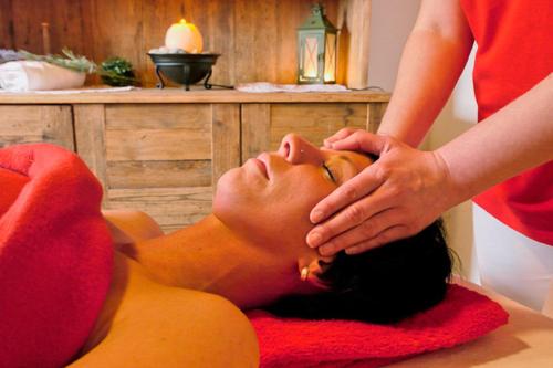 Eine Frau bekommt eine Massage von einem Therapeuten. in der Unterkunft Wofahanslhof in Eschlkam