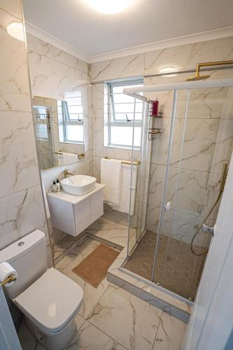 a bathroom with a shower and a toilet and a sink at Modern Beach View in Kingsborough