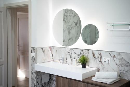 a bathroom with a white sink and two mirrors at Villa La Torre in San Giuliano Terme