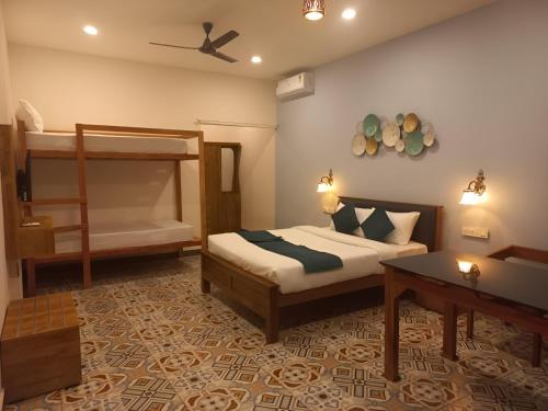un dormitorio con una cama y una litera en The Aradhya Villa, en Wayanad