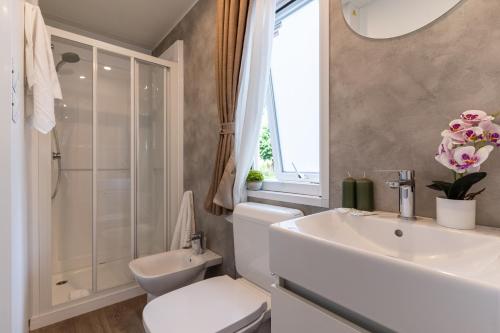 a white bathroom with a sink and a toilet at Club del Sole Adriatico Cervia Easy Camping Village in Cervia