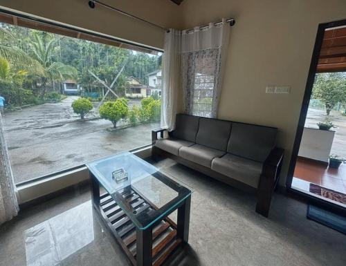 Hallibailu Cottage في Jāmb: غرفة معيشة مع أريكة وطاولة زجاجية