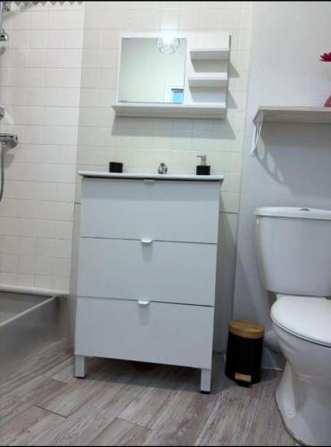 a white bathroom with a sink and a toilet at Appartement cosy calme centre Issoire Belle vue sur le massif du Sancy et le Livradois-Forez WiFi in Issoire