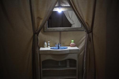 a bathroom with a sink and a mirror at Camel luxury camps Merzouga in Merdani