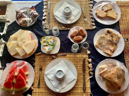 een tafel met borden met eten en desserts bij Camel luxury camps Merzouga in Merdani