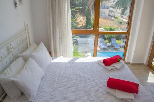 ein Schlafzimmer mit einem weißen Bett mit roten Kissen und einem Fenster in der Unterkunft Villa Tara in Kaş