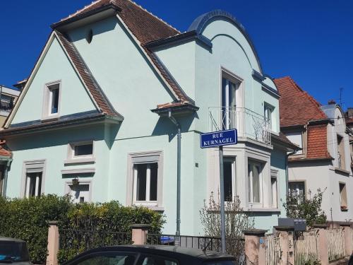 a blue street sign in front of a white house at Charme et authenticité pour 4 personnes 