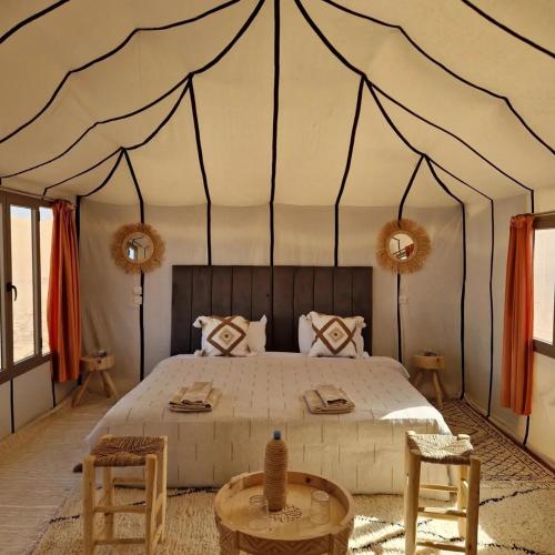 a bedroom with a large bed in a tent at Arawan Luxury Desert Camp in Mhamid