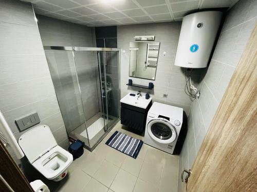 28th Floor Sky City View Apartment في إسكوبية: حمام مع حوض استحمام وغسالة ملابس