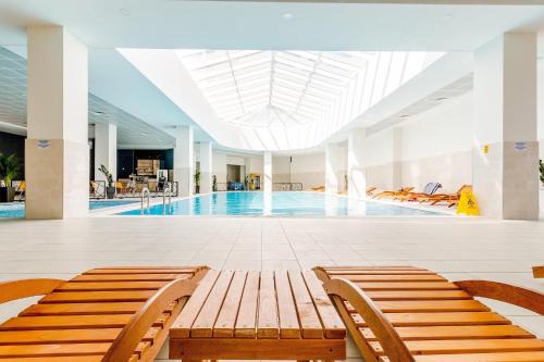 28th Floor Sky City View Apartment في إسكوبية: مسبح مع كراسي في مبنى