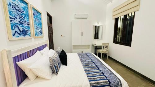 a bedroom with a bed and a desk at Vintage 83 Tangalle in Tangalle